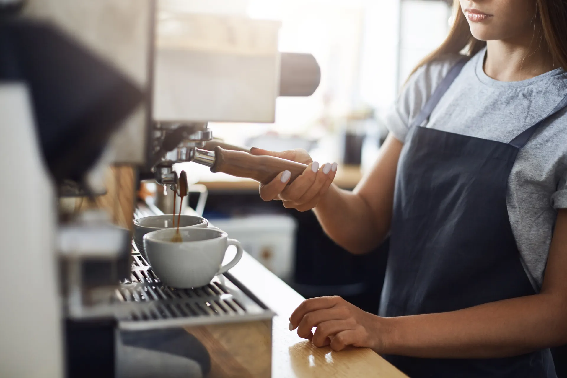Barista preparando caf&eacute; mientras Mottai gestiona sus finanzas